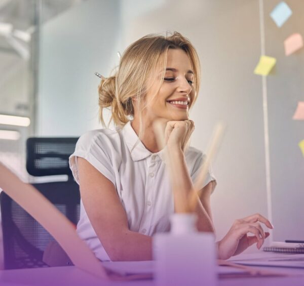 belle-femme-affaires-travaillant-ordinateur-portable-souriante-assise-table-au-bureau